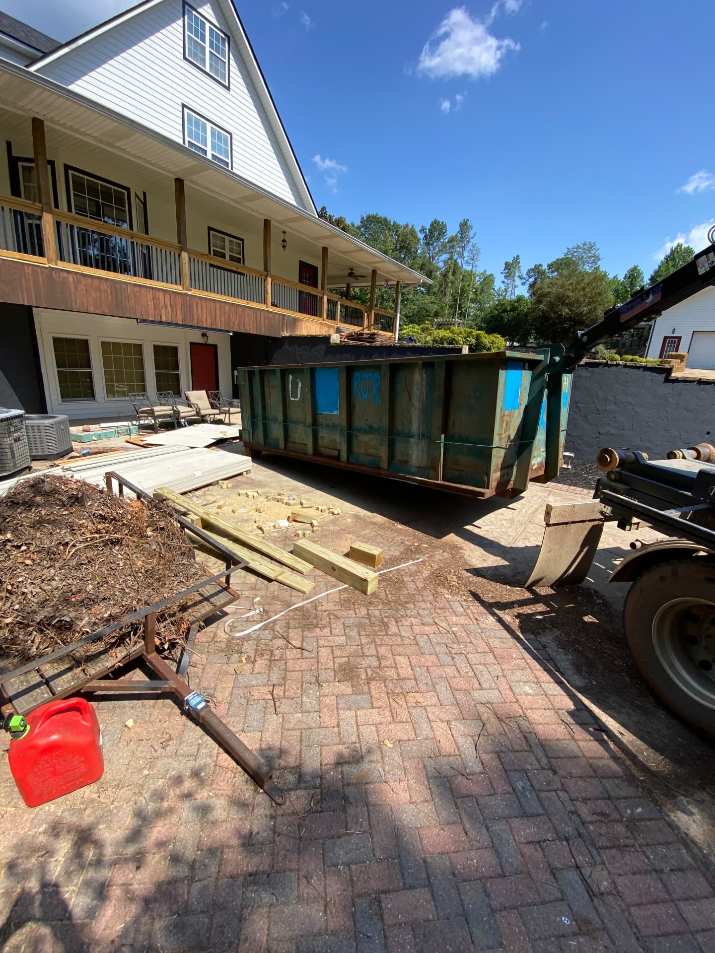 Roll off dumpster loaded with remodel debris beside a home in Calhoun County