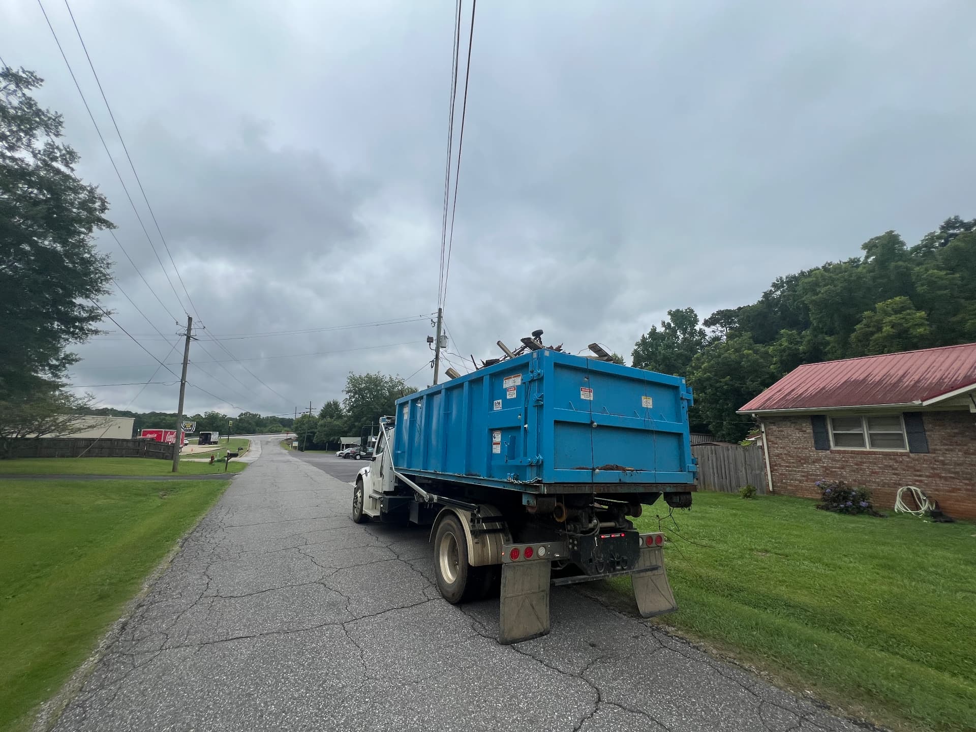 Loaded roll off dumpster being hauled away from a neighborhood job site